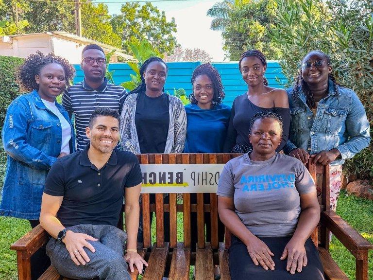 Professor Marcus Rodriguez (lower right) sits with Friendship Bench Zimbabwe workers.